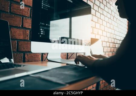 Hacker in the Hood lavorare con il computer con hacking che si rompono in server di dati. Foto Stock