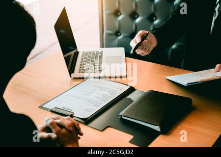 Il responsabile aziendale sta inviando la penna al nuovo dipendente per firmare il contratto della società nella sala ufficio. Foto Stock