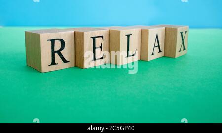 La parola relax fatto da cubetti di legno. Concetto di riposo e tranquillità. Foto Stock