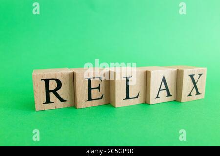 La parola relax fatto da cubetti di legno. Concetto di riposo e tranquillità. Foto Stock