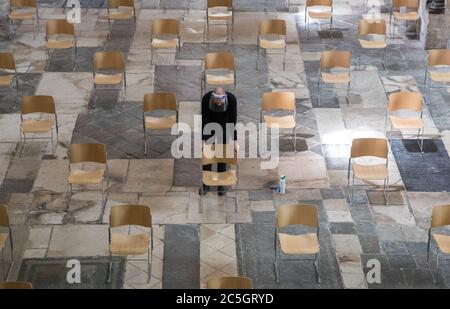 Il Senior Verger Luke Marshall sposta una sedia nella cattedrale di Chichester nel Sussex occidentale, mentre si preparano a riaprire per il culto pubblico il 5 luglio, mentre ulteriori restrizioni di blocco del coronavirus sono revocate in Inghilterra. Foto Stock