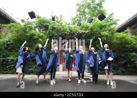 (200703) -- PECHINO, 3 luglio 2020 (Xinhua) -- i laureati gettano i loro cappelli nell'aria all'università di Pechino, capitale della Cina, 2 luglio 2020. L'università di Pechino ha tenuto la sua cerimonia di inizio a Pechino giovedì. A causa delle misure di prevenzione e controllo COVID-19, un numero limitato di laureati ha partecipato alla cerimonia in loco mentre altri hanno partecipato online. (Xinhua/Ren Chao) Foto Stock