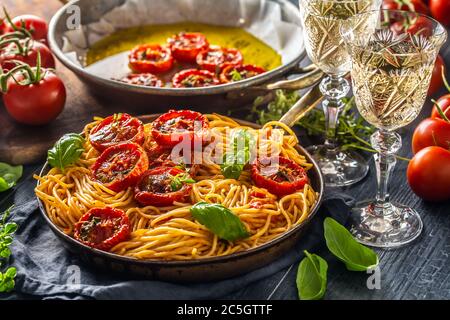 Spaghetti di pasta italiana con pomodori arrostiti timo di basilico origano e vitigno bianco Foto Stock