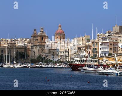 Birgu (Vittoriosa). Malta. Una vista da Senglea sul Dockyard Creek presso il porto turistico e la città di Birgu. Torre e cupola della chiesa di San Lorenzo. Foto Stock