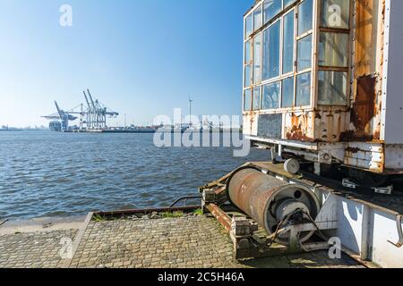 Vecchio porto presso la banchina di Amburgo con terminal container sullo sfondo Foto Stock