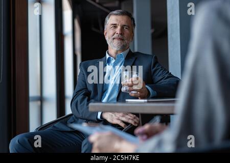 Immagine di uomo d'affari maturo intervistando femmina. Foto Stock