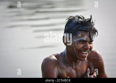 TIKAMGARH, MADHYA PRADESH, INDIA - 13 NOVEMBRE 2019: Ragazzo villaggio indiano che bagna nel fiume la mattina, lavando corpo e capelli con shampoo. Foto Stock