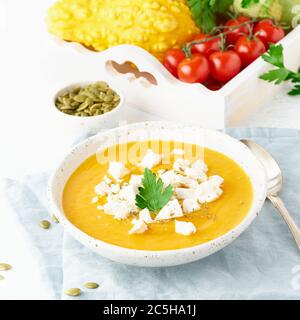 Zuppa di crema di zucca con formaggio feta, cibo casereccio autunnale, fondo bianco, primo piano Foto Stock