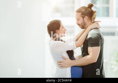 Donna incinta moglie in piedi, abbracciando il marito, guardando insieme con amore e connessione, mostrando il calore di coppia amanti Foto Stock