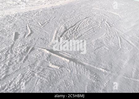 Piste da sci innevate pendenza con tracciato da sci e snowboard a sun giornata invernale Foto Stock