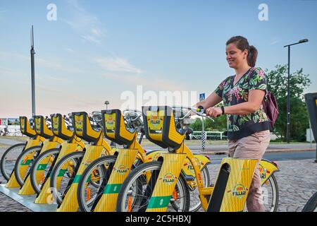 Helsinki / Finlandia - 17 giugno 2018: Donna prende una bicicletta su una stazione di bicicletta Foto Stock