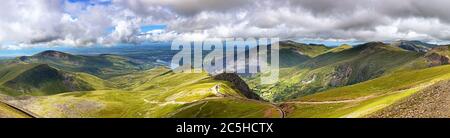 Panorama delle montagne di Snowdonia, guardando dal Monte Snowdon lungo la pista ferroviaria di montagna verso la città di Llanberis Foto Stock