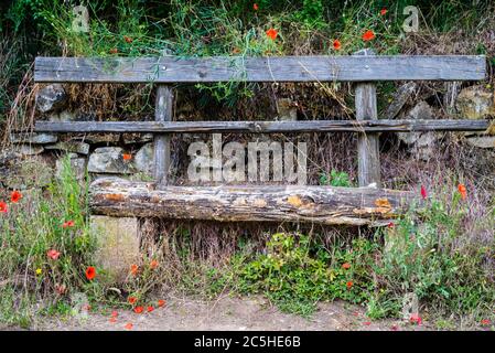 Panca di legno lungo un sentiero escursionistico Foto Stock