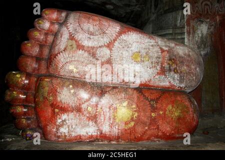 I piedi di una gigantesca statua del Buddha reclinata nella grotta di Dambulla Rock. Staues risalgono al i secolo a.C. Vicino a Kandy, Sri Lanka Foto Stock