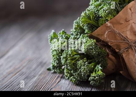 Due mazzetti di broccolini su tavolo di legno. Foto Stock