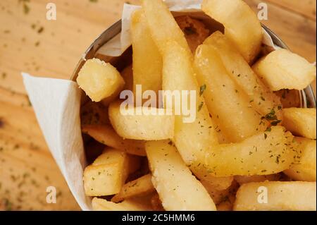 Patatine croccanti in tazza su tavolo di legno vista ravvicinata Foto Stock