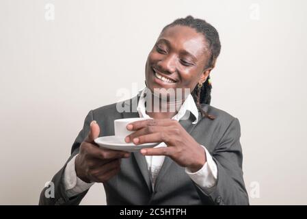 Felice giovane bell'uomo d'affari africano con i Dreadlock bere caffè Foto Stock