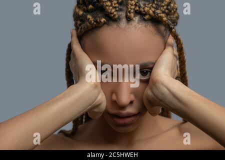 Frustrata giovane afroamericana che ricopre le orecchie con le mani Foto Stock