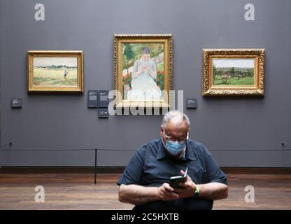 Parigi, Francia. 23 Giugno 2020. Un uomo che indossa una maschera guarda il suo cellulare durante la sua visita al Musee d'Orsay a Parigi, Francia, 23 giugno 2020. A due mesi dalla graduale uscita della Francia dal blocco COVID-19, la circolazione del virus è ora 'sotto controllo' nel paese nonostante la recente identificazione di oltre 200 nuovi gruppi di infezioni, ha detto giovedì il ministro della Sanità Olivier Veran. Credit: Gao Jing/Xinhua/Alamy Live News Foto Stock