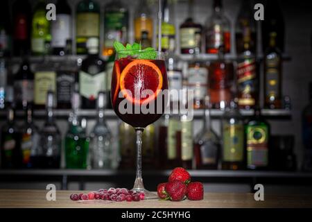 Un rinfrescante cocktail estivo con una fetta di arancia. Bevanda alcolica di Aperol. Decorata con un rametto di menta e cubetti di ghiaccio. Primo piano. Foto Stock