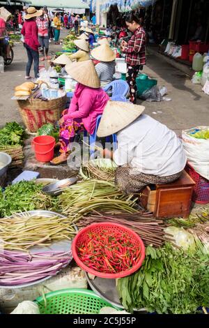 Donne vietnamite stallholder con cappelli conici che mostrano frutta e verdura fresca locale in vendita in un mercato alimentare. CAN Tho Mekong Delta Vietnam Foto Stock