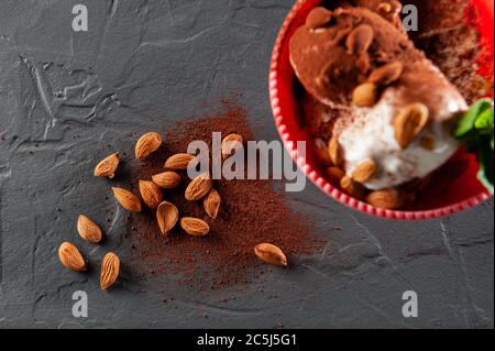 gelato alla menta e cacao su sfondo grigio in una tazza rosa. Vista dall'alto e disposizione piatta Foto Stock