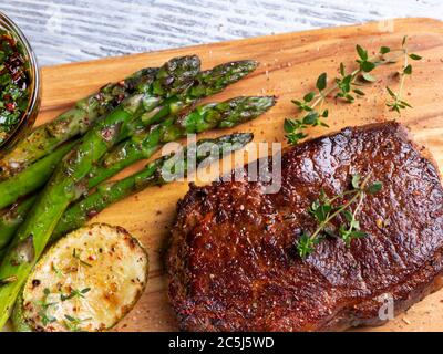 succulenta bistecca arrosto con asparagi, pepe, zucchine, salsa da primo piano Foto Stock