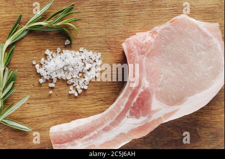 carne per bistecche sulla tavola con spezie vista grossolanamente dall'alto Foto Stock