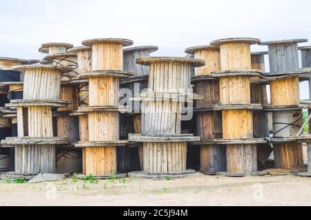 Le bobine vuote di un cavo ad alta tensione giacciono su un'uscita Foto Stock