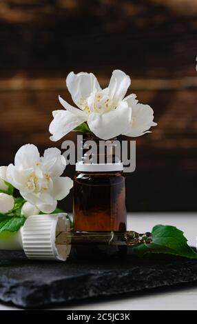 prodotto cosmetico naturale, olio di gelsomino con bottiglie di vetro su tavolo di legno Foto Stock