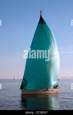 Barca a vela con spinnaker verde durante la regata Foto Stock