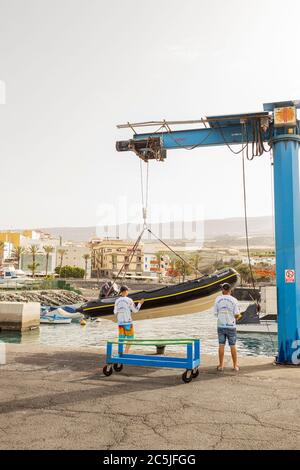 Preparandosi a lanciare una GOMMONI RIGIDA, RIB in gru da Playa San Juan, Tenerife, Isole Canarie, Spagna Foto Stock