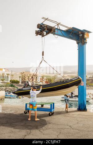 Preparandosi a lanciare una GOMMONI RIGIDA, RIB in gru da Playa San Juan, Tenerife, Isole Canarie, Spagna Foto Stock