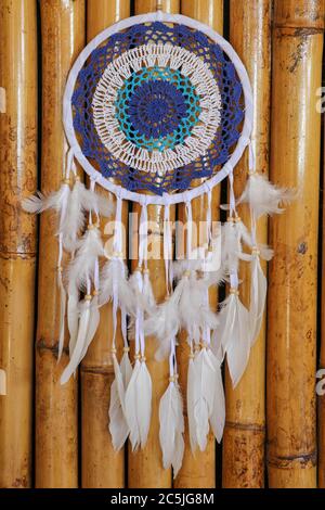 Blue Dreamcatcher con piume e perline isolate su uno sfondo wodden. Foto Stock