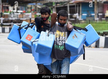 Guwahati, Assam, India. 3 luglio 2020. I lavoratori portano la scatola medica in un centro di raccolta di tamponi, durante il blocco totale imposto dal governo di Assam per frenare la diffusione del nuovo coronavirus, a Guwahati. Credit: David Talukdar/ZUMA Wire/Alamy Live News Foto Stock