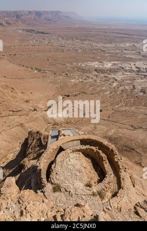 Israele, la terrazza centrale del Palazzo Nord di Erode a Masada conteneva una sala di ricevimento circolare con un tetto a punta sostenuto da colonne. Rovine della fortezza di Masada nel deserto della Giudea d'Israele. Il Parco Nazionale di Masada è un sito patrimonio dell'umanità dell'UNESCO. Nel deserto sottostante è un altro dei forti romani o castra che circondavano Masada durante la seige. Foto Stock