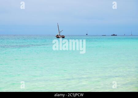 Dhow barca a vela nell'oceano Indiano all'alba, Zanzibar, Tanzania, Africa Foto Stock