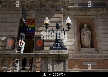 Con 184 morti di Covid nel Regno Unito nelle ultime 24 ore, un totale ora di 43,414, un impiegato del museo posiziona un poster per l'evento annuale LGBT Pride alla galleria Pace della Royal Academy. L'orgoglio 2020 è stato annullato a causa della pandemia di Coronavirus, il 26 giugno 2020, a Londra, Inghilterra. Le restrizioni governative sono previste per facilitare le gallerie d'arte come la RA, con i piani di riapertura il 4 luglio. La riapertura dei luoghi sarà subordinata alla progressione del virus e alla buona implementazione delle misure di allontanamento sociale. Foto Stock