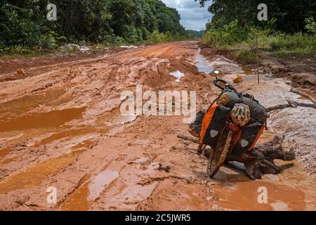 La strada sterrata Linden-Lethem, che attraversa la giungla di Guyana, in Sud America, è sporca e fangosa Foto Stock