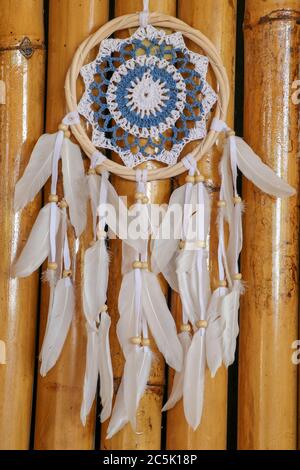 Blue Dreamcatcher con piume e perline isolate su uno sfondo wodden. Foto Stock