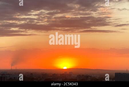 Sole che sorge sullo skyline della città di Almaty, Kazakistan Foto Stock