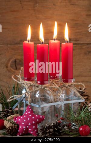 decorazione di natale con l'avvento candele rosse in bottiglie di vetro Foto Stock