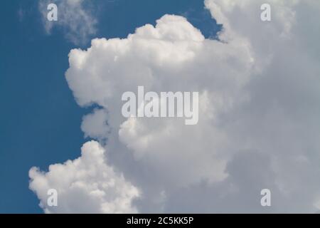 Le nuvole Cumulus si costruiscono in un cielo blu scuro prima di una tempesta di pioggia. Foto Stock