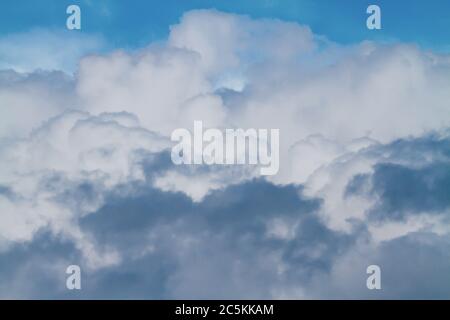 Le nuvole Cumulus si costruiscono in un cielo blu scuro prima di una tempesta di pioggia. Foto Stock