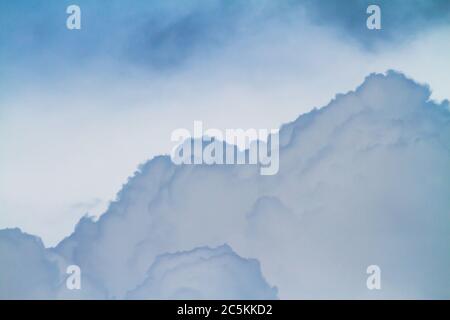 Le nuvole Cumulus si costruiscono in un cielo blu scuro prima di una tempesta di pioggia. Foto Stock