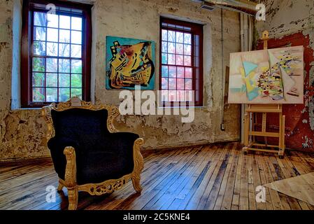 Vista di uno studio d'arte con una sedia vuota e pittura su un cavalletto. Foto Stock