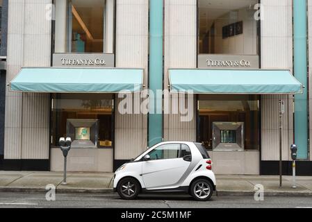 Una Smart car bianca e grigia si trova parcheggiata fuori dal negozio di gioielli Tiffany & Co. Nel centro di Vancouver, British Columbia, Canada. Foto Stock