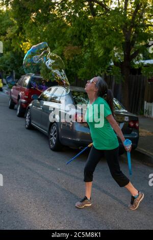 Questa donna crea bolle come un modo per regolare il suo atteggiamento a San Rafael, CA. Foto Stock