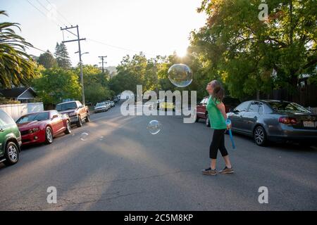 Questa donna crea bolle come un modo per regolare il suo atteggiamento a San Rafael, CA. Foto Stock