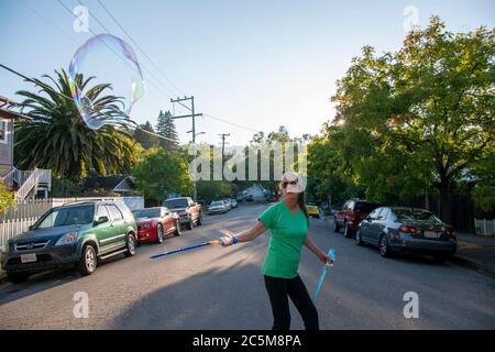 Questa donna crea bolle come un modo per regolare il suo atteggiamento a San Rafael, CA. Foto Stock